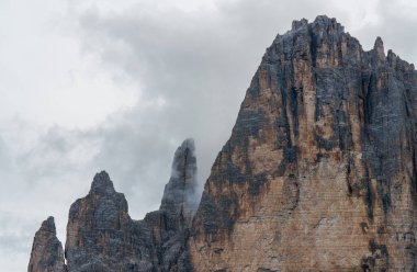 Dolomitlerdeki sisli bulutların arasından Drei Zinnen (Tre Cime di Lavaredo) yükselir. Nefes kesici ve mistik dağ manzarası gücü ve güzelliği gözler önüne seriyor.