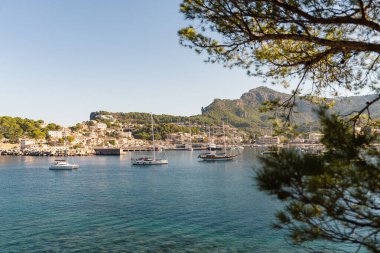 Port de Soller, İspanya kıyısı boyunca demirlemiş motorlu teknelerin manzarası. Sakin deniz yüzeyi, güneşli gündüz atmosferli deniz romantizmi. Seyahat, deniz tatili, yat, sahil hayatı..