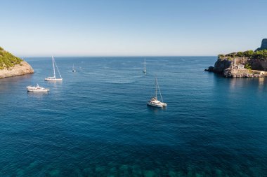 Resimli liman limanı Port de Soller 'da demirlemiş zarif yatlar güneşli bir günde sakin deniz yüzeyinde. Mallorca, İspanya, Balear Adaları. Seyahat, deniz eğlencesi, yat gezisi.,
