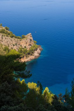 Serra de Tramuntana, Mallorca, İspanya dağlarıyla çevrili tenha bir sahil manzarası. Kristal su, resimli kayalıklar, yeşil dağlar..