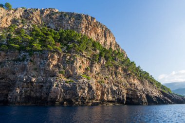 Engebeli dağların aniden kristal berrak denize düştüğü Mallorca 'nın çarpıcı sahil şeridini izleyin. Doğal güzellik Balear Adaları. Sahne, Mallorca 'nın eşsiz çekiciliğini yakalar