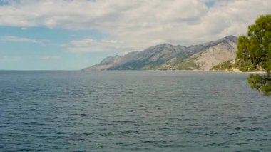 Hırvatistan 'ın Brela kentinin çarpıcı hava manzarası. Kristal berrak turkuaz sularla çevrili uçurum boyunca İHA uçuşu. Doğanın güzelliği 