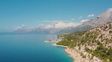 Hırvatistan 'ın Makarska kenti ve kristal berrak sulara sahip Dalmaçya havacılık manzarası. Gökyüzüne dağılmış güzel bulutlarla görkemli dağlar huzur ve resim gibi manzaralar yaratıyor.. 