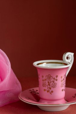 Minimalist, pembe fincanlı, fincanı koyu renk olan bir fincan tabağı. Boşluğu kopyala