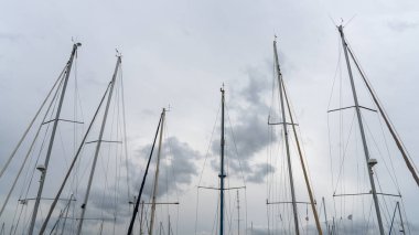 Yelkensiz yelkenli yatların direkleri, berrak mavi gökyüzüne karşı siluet. Liman ya da marinalar. Seyahat.