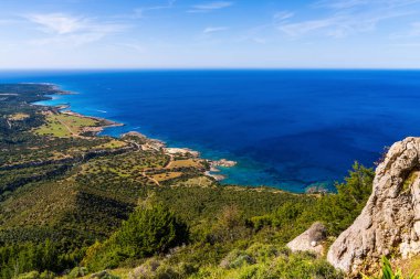 Kıbrıs 'ın engebeli ve kayalık kıyı şeridi, turkuaz sular ve dik deniz kayalıklarıyla sersemletici panoramik manzarası. Yaz Akdeniz manzarası, vahşi doğa ve doğal manzara.