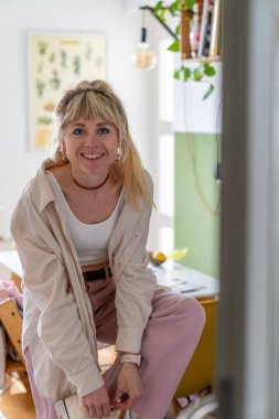 Spor ayakkabılarına bağcık bağlayan, dışarı çıkan, günlük kıyafetlerle neşeli genç bir kadın. Rahat hafta sonu atmosferi, aktif yaşam tarzı, güneşli bir gün..