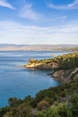 Kıbrıs Rum Kesimi 'nin berrak mavi suları ve parlak güneşli gökyüzünün altında engebeli kıyı şeridi manzarası. Güzel doğa ve manzaralı yaz tatili için ideal bir yer..