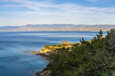 Kıbrıs 'ın güzel deniz manzarası açık gökyüzünün altında engebeli kıyı şeridi ve şeffaf denizi gösteriyor. Turizm, tatil ve açık hava macerası için mükemmel bir zemin
