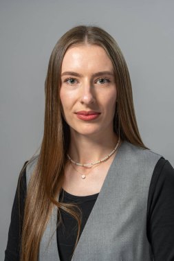 Profesyonel stüdyo ortamında sakin ve şık makyajlı genç ve çekici bir kadın. Tarafsız arka plan modern ve doğal görünümü geliştirir..