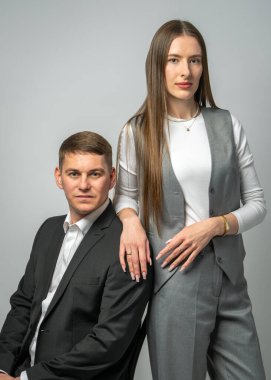 Güzel genç bir çift. Adam sandalyeye oturur, kız sırtına yaslanır. Şık, modern giysiler içinde. Stüdyo portresi. Moda ve ilişki kavramı