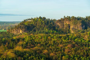 Almanya, Sakson İsviçre 'deki ünlü Bastei Köprüsü yakınlarında dramatik kumtaşı oluşumları. Küçük ev uçurumların tepesinde, orman ve nefes kesici doğal manzarayla çevrili..
