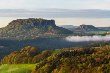 Lilienstein Dağı ve Sakson İsviçre 'deki Koenigstein Kalesi' nin yer aldığı görkemli bir manzara. Açık hava maceraları ve manzara fotoğrafçılığı için popüler bir yer..