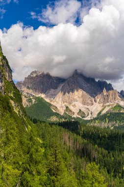 Yoğun bulutlar Dolomitlerin sivri tepelerini örterek nefes kesici, atmosferik alp manzarası oluşturur. Vahşi doğa, dağ havası, macera, doğal güzellik kavramları için ideal..