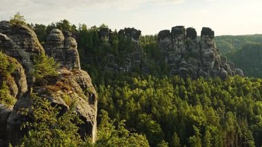 Almanya 'nın Sakson İsviçre Ulusal Parkı' ndaki Bastei Köprüsü 'nden görülen görkemli kumtaşı kayalıklarının nefes kesici manzarası. İkonik Avrupa doğa manzarası seyahat ve macera temaları için mükemmel