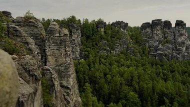 Almanya 'nın Sakson İsviçre Ulusal Parkı' ndaki yüksek kumtaşı uçurumlarının Bastei Köprüsü 'nden çarpıcı bir manzara. İkonik Avrupa manzarası doğa, seyahat, açık hava temaları için idealdir