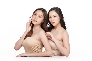 Beyaz arka planda temiz tenli iki güzel Asyalı kadın, yüz bakımı, yüz bakımı, kozmetoloji, güzellik ve kaplıca, Asyalı kadın portresi..