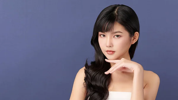 Beautiful young asian woman with clean fresh skin on Blue background, Face care, Facial treatment, Cosmetology, beauty and spa, Asian women portrait.