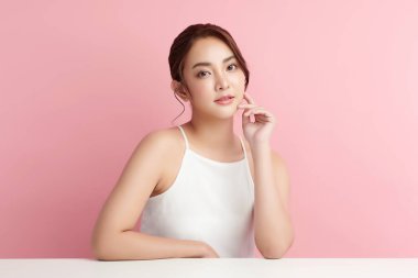 Pembe arka planda temiz tenli güzel Asyalı kadın, yüz bakımı, yüz bakımı, kozmetoloji, güzellik ve kaplıca, Asyalı kadın portresi.