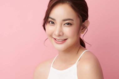 Pembe arka planda temiz tenli güzel Asyalı kadın, yüz bakımı, yüz bakımı, kozmetoloji, güzellik ve kaplıca, Asyalı kadın portresi.