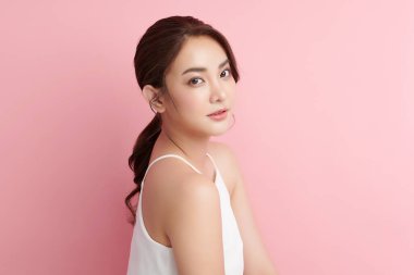 Pembe arka planda temiz tenli güzel Asyalı kadın, yüz bakımı, yüz bakımı, kozmetoloji, güzellik ve kaplıca, Asyalı kadın portresi.