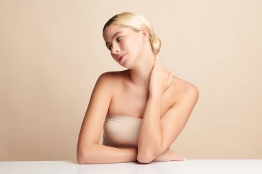 Bej arkaplan, yüz bakımı, yüz bakımı, kozmetoloji, güzellik ve kaplıca gibi temiz cilde sahip güzel genç bir kadın.,