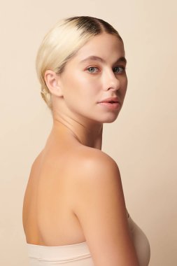 Bej arkaplan, yüz bakımı, yüz bakımı, kozmetoloji, güzellik ve kaplıca gibi temiz cilde sahip güzel genç bir kadın.,