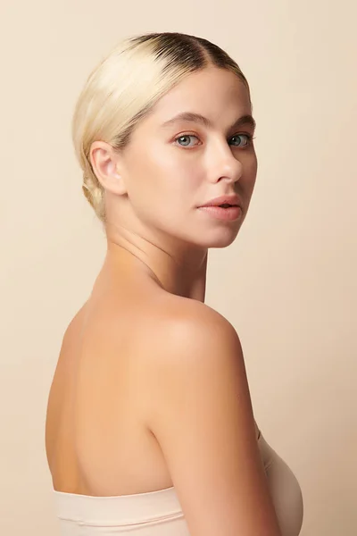ベージュの背景にきれいな新鮮な肌を持つ美しい若い女性 顔のケア フェイシャルトリートメント 美容とスパ — ストック写真