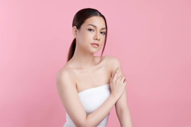 Pembe arka planda temiz tenli güzel Asyalı kadın, yüz bakımı, yüz bakımı, kozmetoloji, güzellik ve kaplıca, Asyalı kadın portresi.