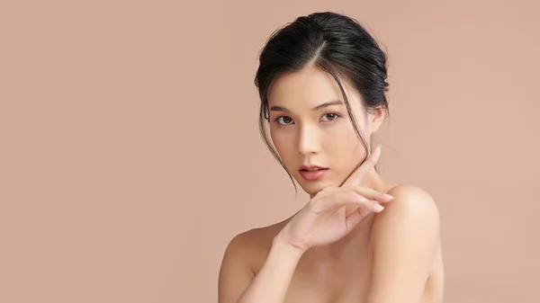 Beautiful young asian woman with clean fresh skin on beige background, Face care, Facial treatment, Cosmetology, beauty and spa, Asian women portrait.