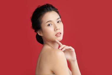 Güzel genç Asyalı kadın, kırmızı arka planda temiz ten, yüz bakımı, yüz bakımı, kozmetoloji, güzellik ve kaplıca, Asyalı kadın portresi..