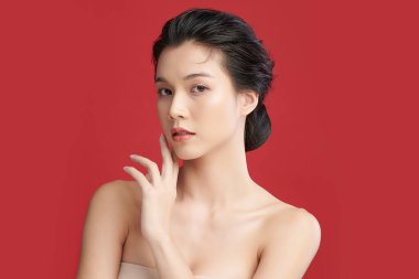 Güzel genç Asyalı kadın, kırmızı arka planda temiz ten, yüz bakımı, yüz bakımı, kozmetoloji, güzellik ve kaplıca, Asyalı kadın portresi..