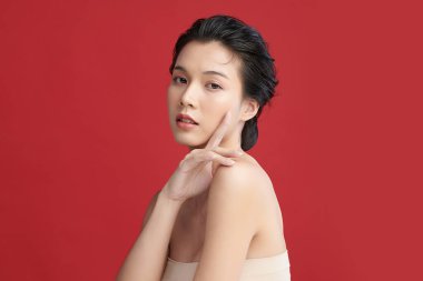 Güzel genç Asyalı kadın, kırmızı arka planda temiz ten, yüz bakımı, yüz bakımı, kozmetoloji, güzellik ve kaplıca, Asyalı kadın portresi..