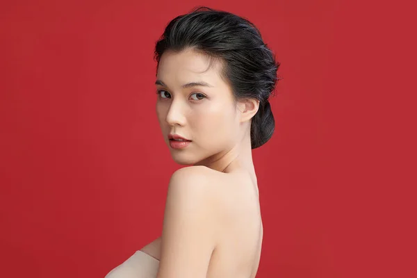 Beautiful young asian woman with clean fresh skin on red background, Face care, Facial treatment, Cosmetology, beauty and spa, Asian women portrait.