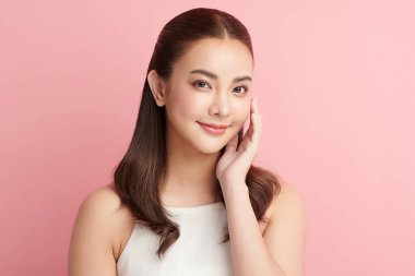 Pembe arka planda temiz tenli güzel Asyalı kadın, yüz bakımı, yüz bakımı, kozmetoloji, güzellik ve kaplıca, Asyalı kadın portresi.