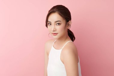 Pembe arka planda temiz tenli güzel Asyalı kadın, yüz bakımı, yüz bakımı, kozmetoloji, güzellik ve kaplıca, Asyalı kadın portresi.