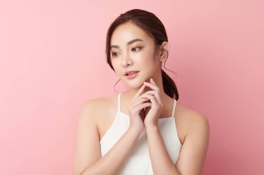 Pembe arka planda temiz tenli güzel Asyalı kadın, yüz bakımı, yüz bakımı, kozmetoloji, güzellik ve kaplıca, Asyalı kadın portresi.