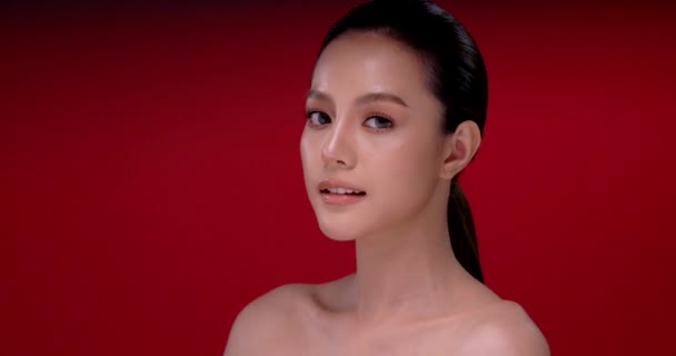 赤の背景にきれいな新鮮な肌を持つ美しい若いアジアの女性 顔のケア 顔の治療 美容とスパ アジアの女性の肖像画 — ストック動画