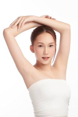 Güzel genç Asyalı kadın temiz ve hijyenik koltuk altlarını göstermek için ellerini kaldırıyor ya da beyaz arka planda koltukaltı, koltukaltı temizliği ve korunma kavramı