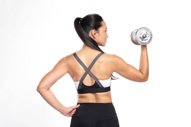 Asyalı bir kadın, beyaz arka planda spor kıyafeti giymiş halterlerle spor yapıyor.,