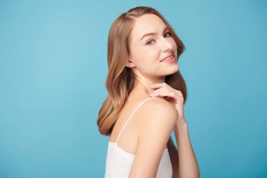 Mavi arka planda taze cildi temiz genç bir kadın, yüz bakımı, yüz bakımı, kozmetoloji, güzellik ve kaplıca, kadın portresi.