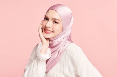 Pembe arka planda pembe tesettürlü güzel Asyalı Müslüman kadın, Arap Güzelliği Portresi.