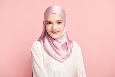 Pembe arka planda pembe tesettürlü güzel Asyalı Müslüman kadın, Arap Güzelliği Portresi.