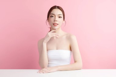 Pembe arka planda temiz tenli güzel Asyalı kadın, yüz bakımı, yüz bakımı, kozmetoloji, güzellik ve kaplıca, Asyalı kadın portresi.