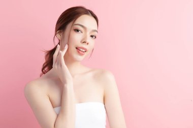 Pembe arka planda temiz tenli güzel Asyalı kadın, yüz bakımı, yüz bakımı, kozmetoloji, güzellik ve kaplıca, Asyalı kadın portresi.