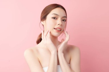 Pembe arka planda temiz tenli güzel Asyalı kadın, yüz bakımı, yüz bakımı, kozmetoloji, güzellik ve kaplıca, Asyalı kadın portresi.