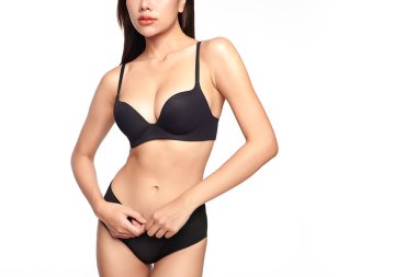 Beyaz arka planda siyah iç çamaşırlarıyla poz veren kendinden emin, genç Asyalı bir kadın.,