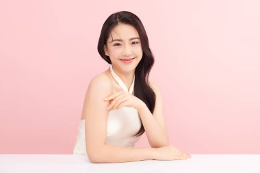 Pembe arka planda temiz tenli güzel Asyalı kadın, yüz bakımı, yüz bakımı, kozmetoloji, güzellik ve kaplıca, Asyalı kadın portresi.