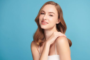 Mavi arka planda taze cildi temiz genç bir kadın, yüz bakımı, yüz bakımı, kozmetoloji, güzellik ve kaplıca, kadın portresi.