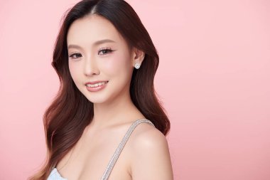 Pembe arka planda temiz tenli güzel Asyalı kadın, yüz bakımı, yüz bakımı, kozmetoloji, güzellik ve kaplıca, Asyalı kadın portresi.